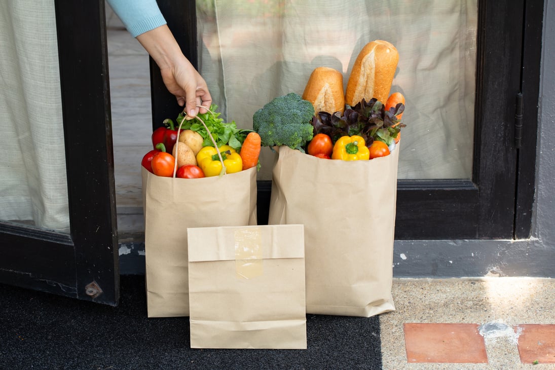 Person Picking Up Groceries from the Doorstep